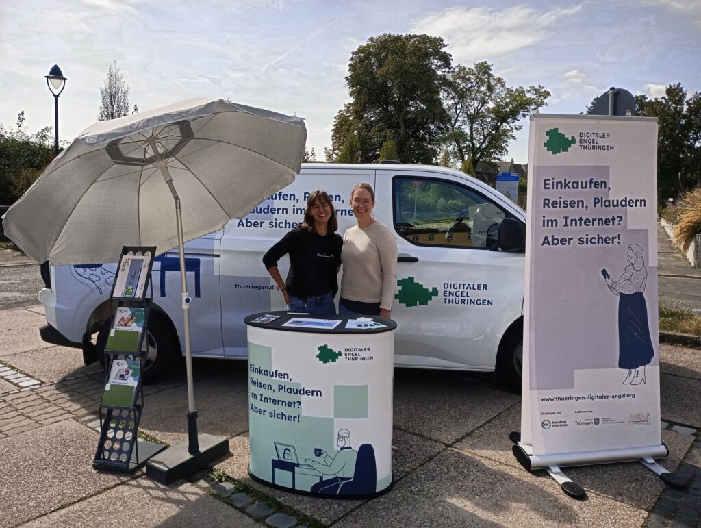 Stand von Digitalen Engeln Thüringen mit Informationsmaterialien und zwei Personen, die über Internetnutzung informieren.