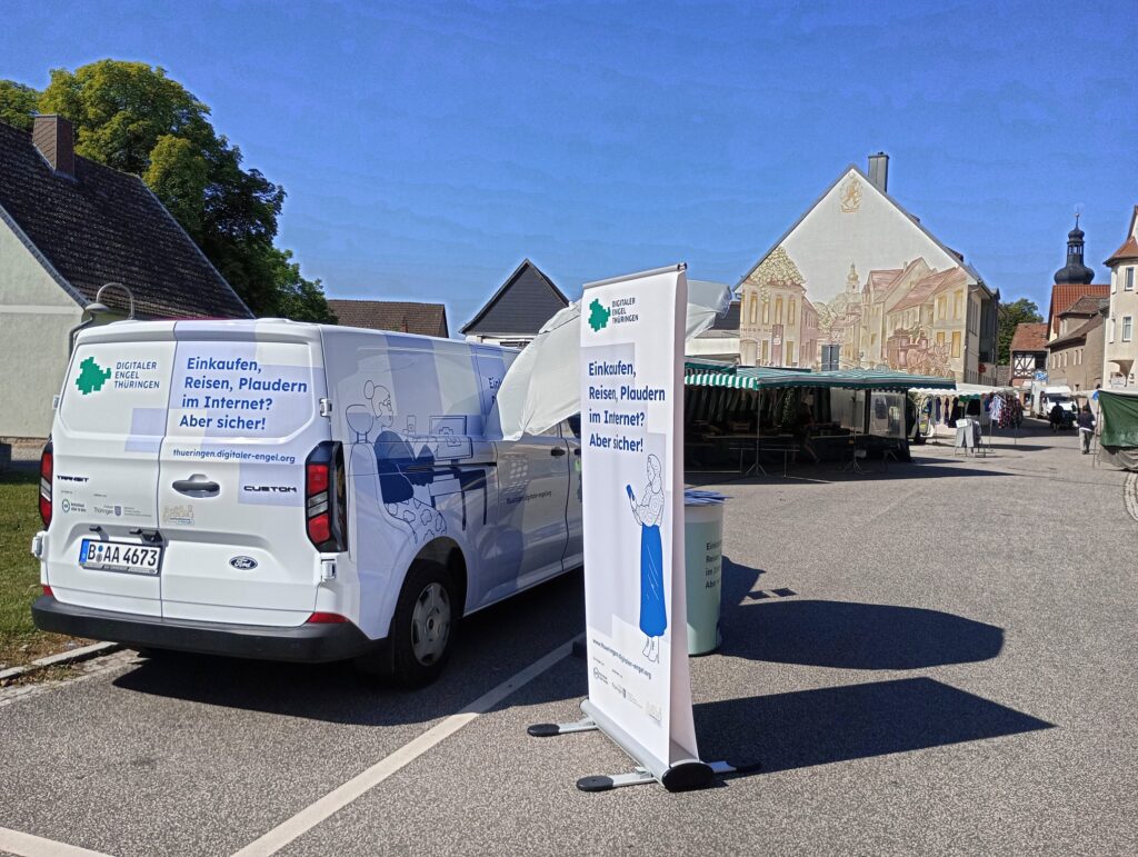 Auto des Digitalen Engel Thüringen mit Informationsstand auf dem Wochenmarkt bei schönem Sonnenschein.